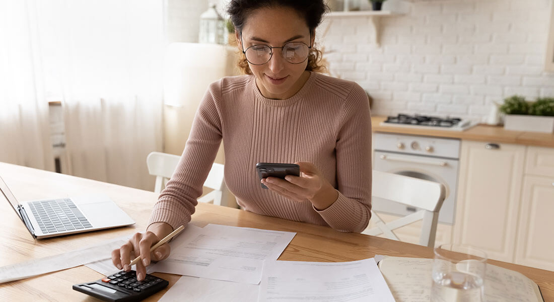 Woman working on phone with calculator